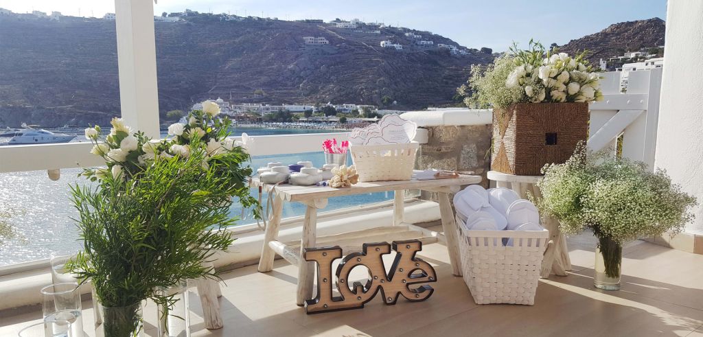 A table adorned with white roses, disposable cameras, and a basket of white disposable slippers