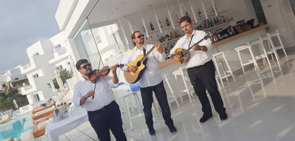 A group of three local musicians playing traditional Myconian songs